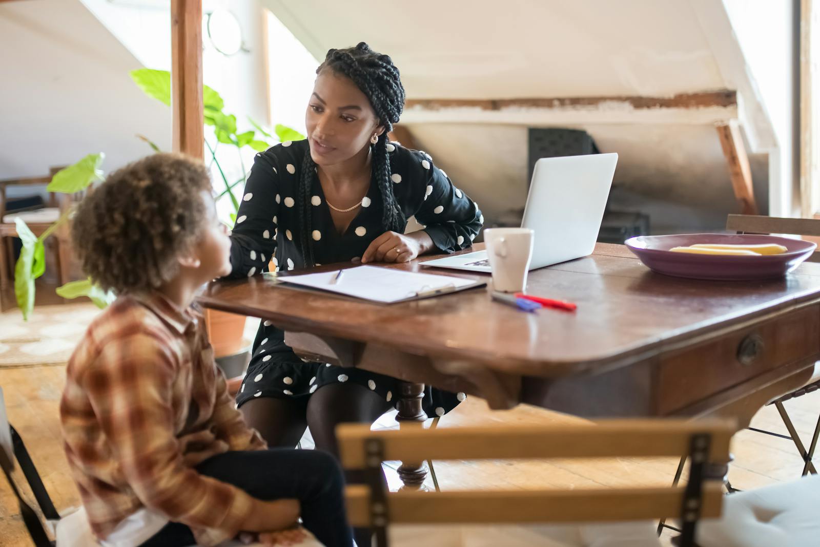 A mother and son spending quality time together at a table, engaged in conversation and homework.
