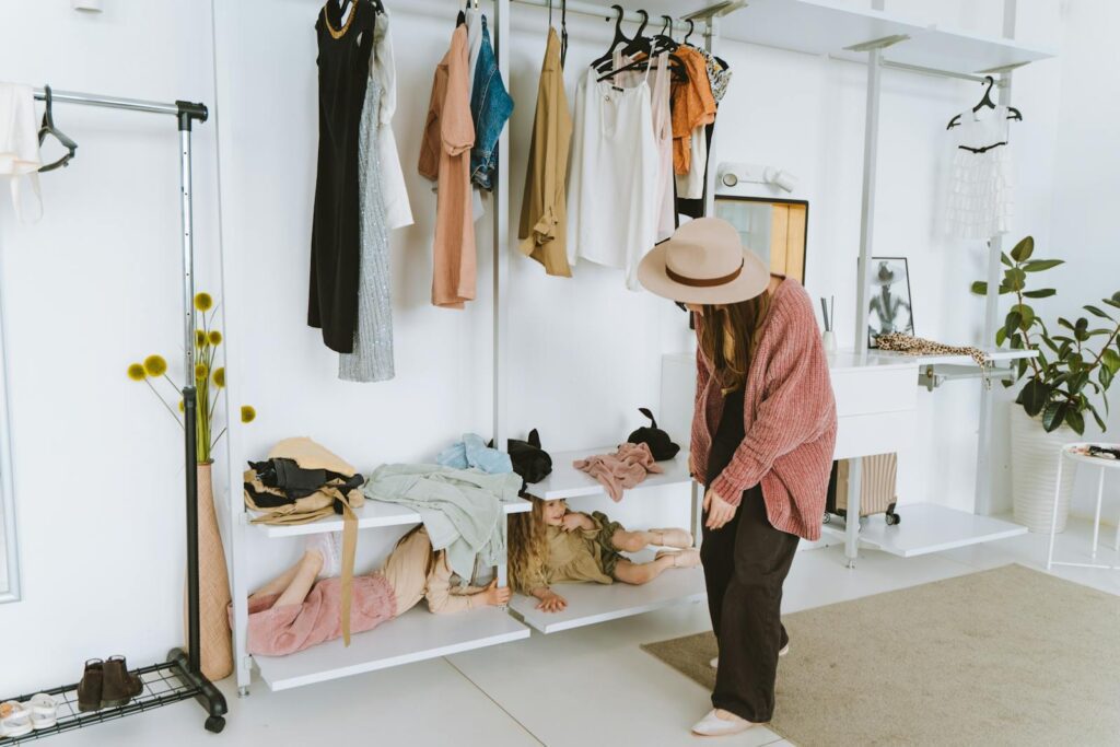 A woman enjoys a fun moment with kids hiding in a wardrobe space. Light and stylish interior.