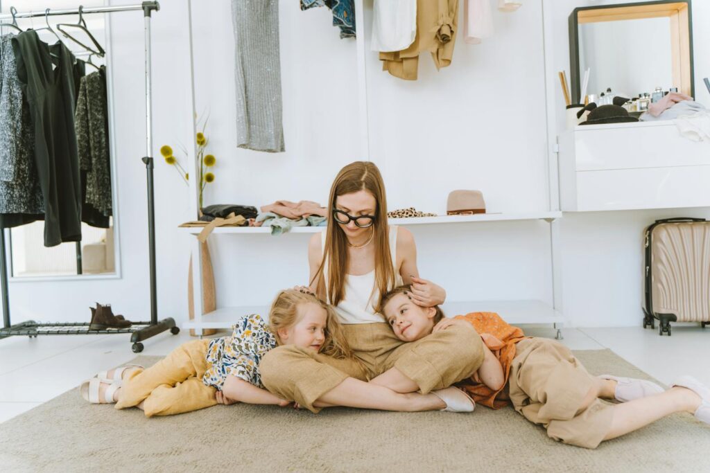 A mother sitting on the floor with her two daughters, enjoying a cozy moment in a modern room.
