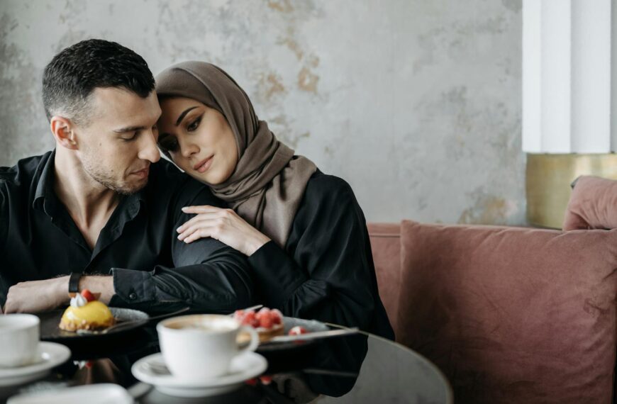 A loving Muslim couple sitting together in a cozy café setting, enjoying a serene moment.