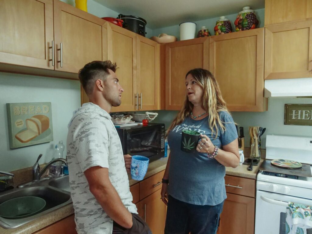 Mother and son enjoying a casual conversation in the kitchen over coffee.