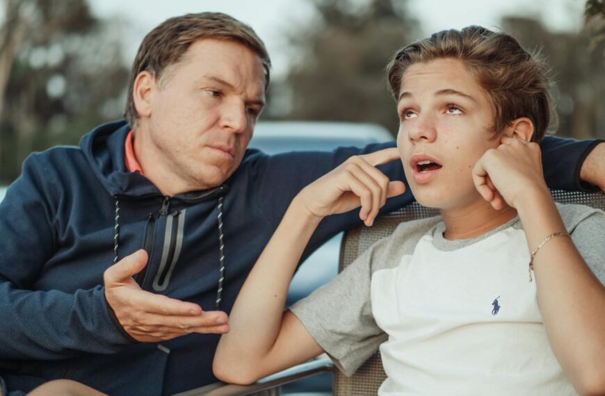 A father and teenage son having an intense conversation, capturing the essence of family dynamics and communication.