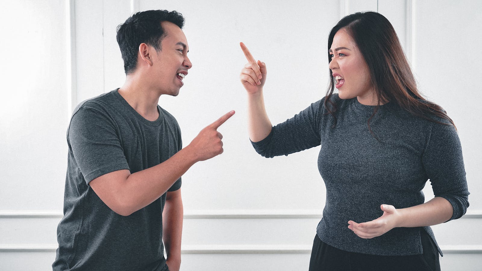A couple engaged in a heated argument at home, expressing strong emotions.
