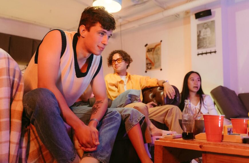 A group of teenagers hanging out in a cozy living room at a casual party.