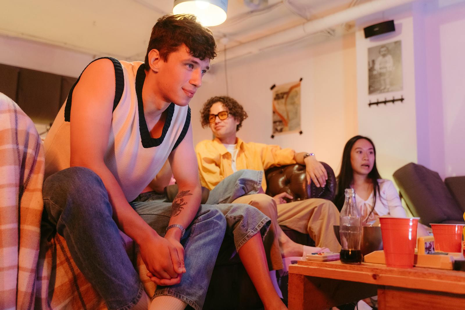 A group of teenagers hanging out in a cozy living room at a casual party.