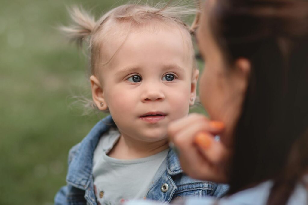 A heartwarming portrait of a mother and child sharing a moment outdoors, capturing love and joy.