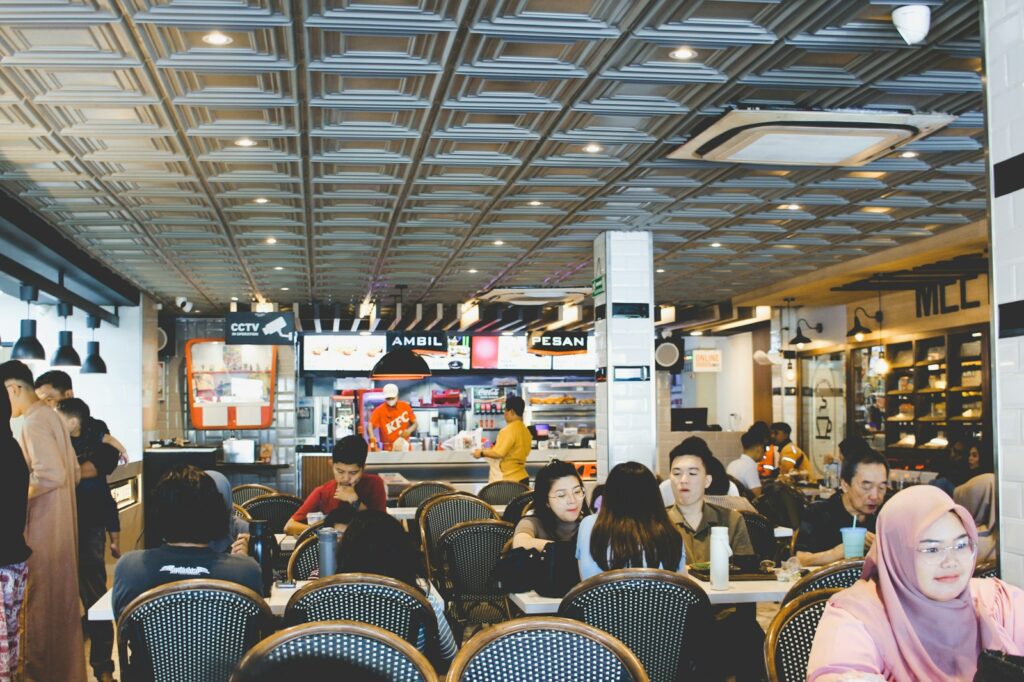 People dining inside a busy restaurant with modern decor.