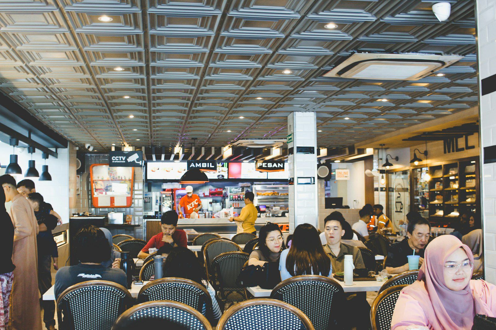 People dining inside a busy restaurant with modern decor.