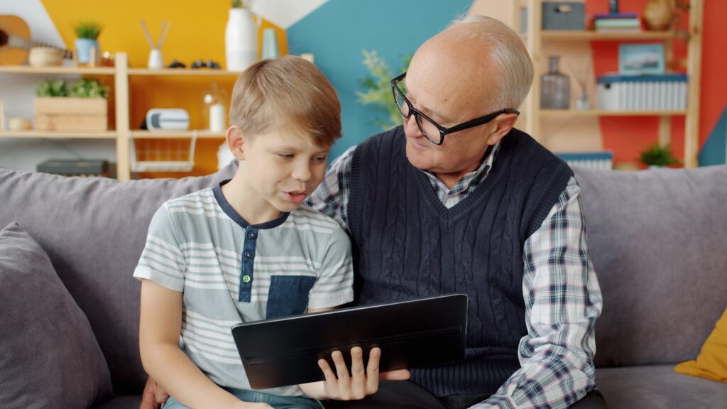 Grandfather and grandson looking at tablet together.