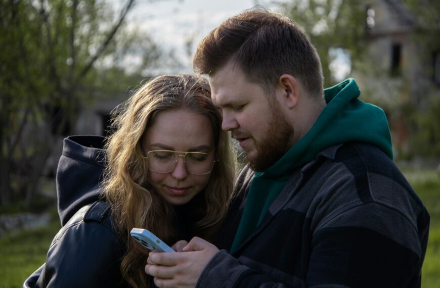 a man and a woman looking at a cell phone