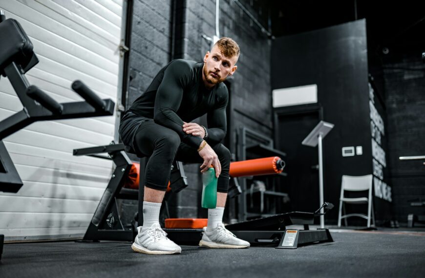 woman in black long sleeve shirt and black pants sitting on exercise equipment