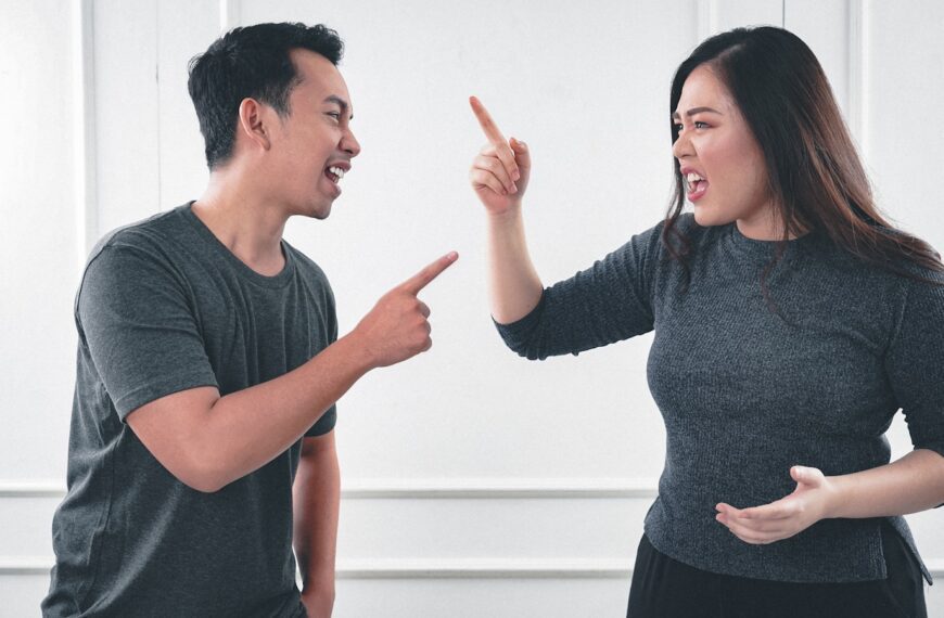 man in gray crew neck long sleeve shirt standing beside woman in black crew neck shirt