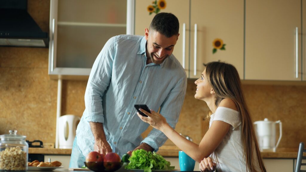 Couple looking at phone in a bright kitchen