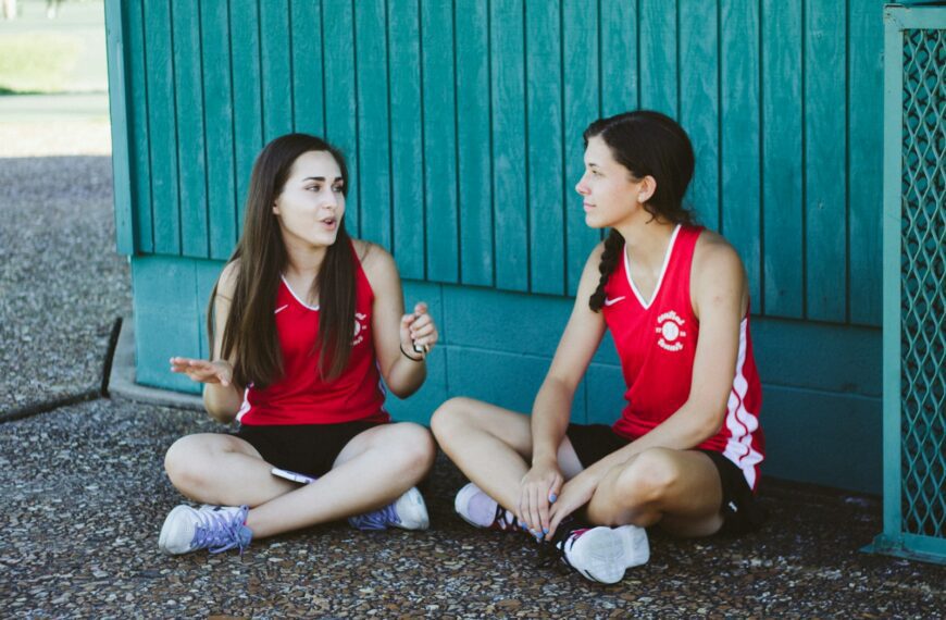 woman in red Nike tank top sitting beside woman in red tank top
