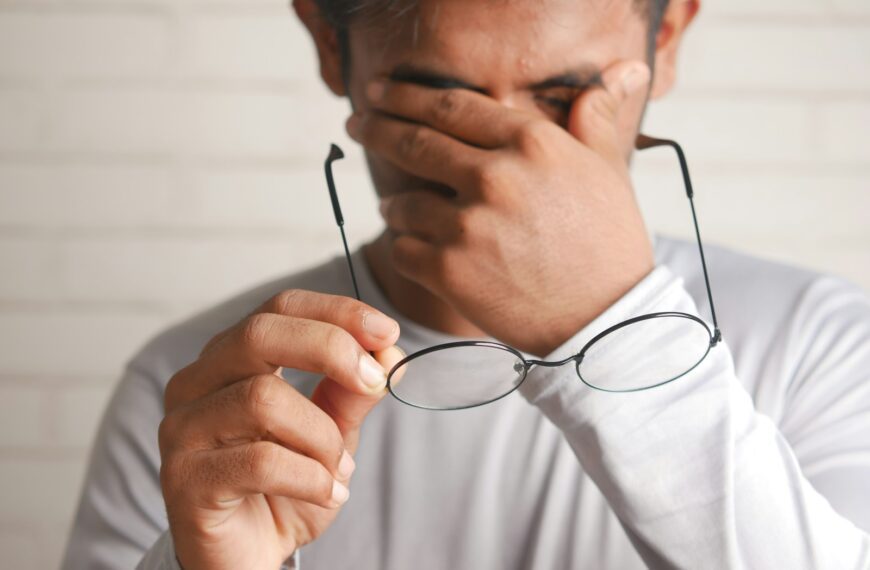 a man holding a pair of glasses up to his face