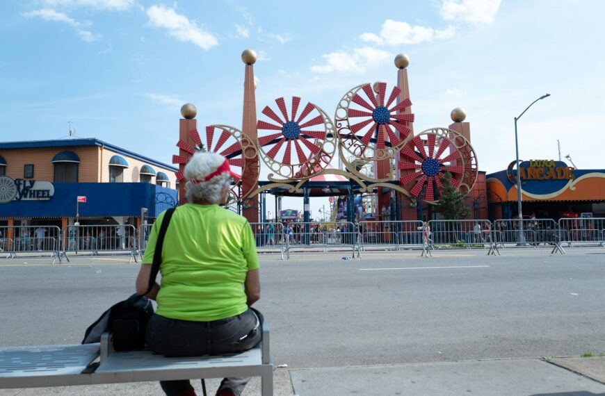 Woman sits facing amusement park rides