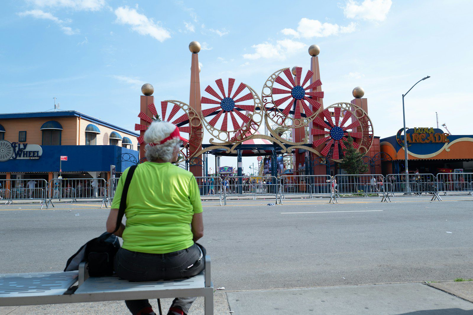Woman sits facing amusement park rides
