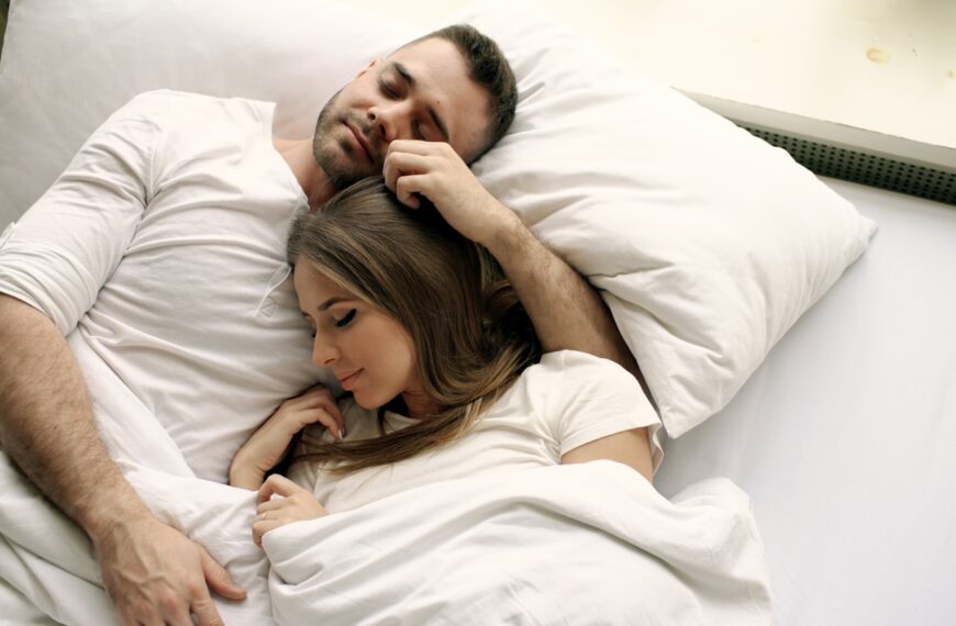 Couple sleeping peacefully in bed together.