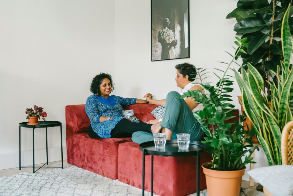 a woman sitting on a couch talking to another woman