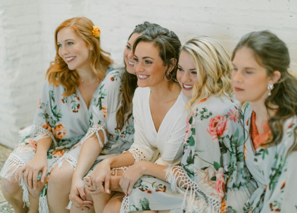 Five women in floral robes smiling together