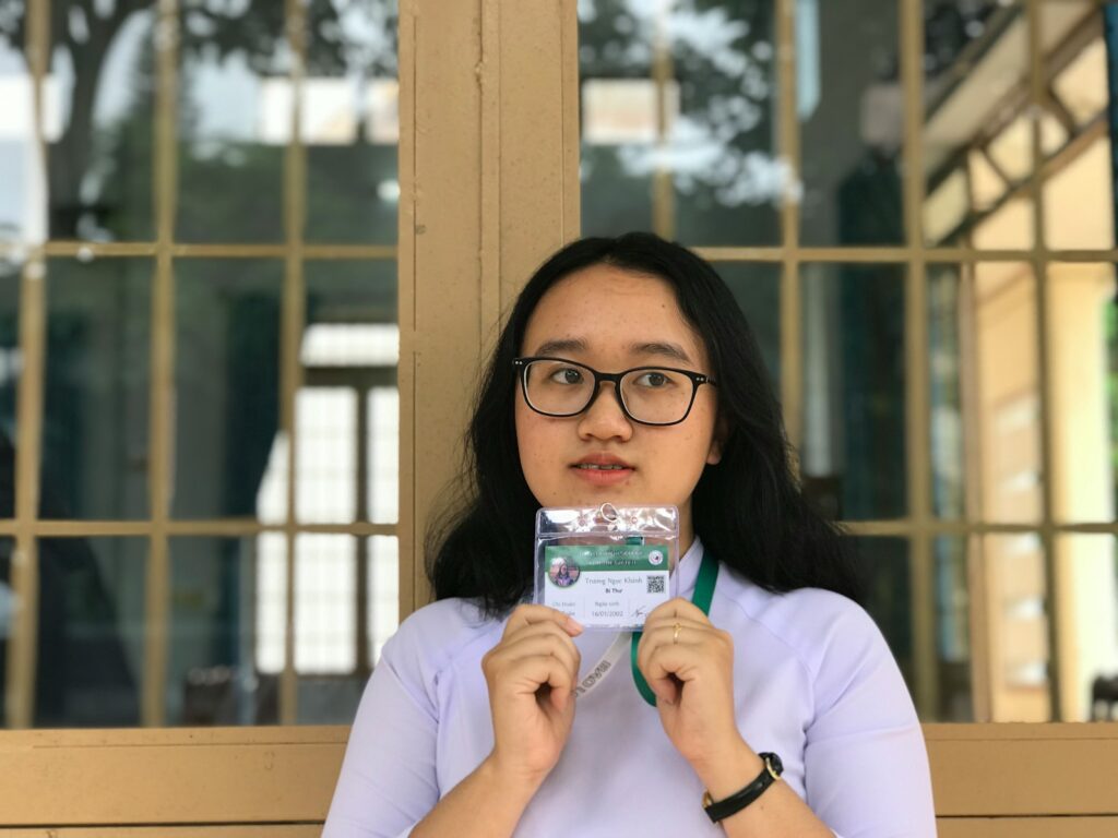 woman holding green and white identification card