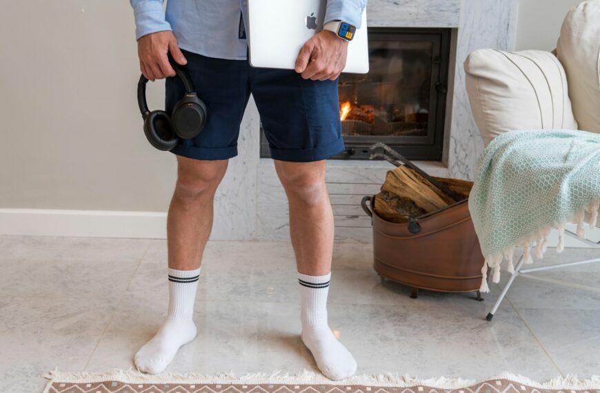 a man standing in front of a fireplace holding a camera