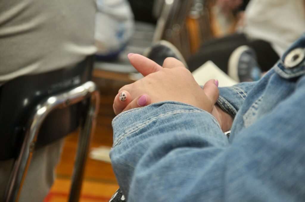 a person sitting in a chair with a ring on their finger