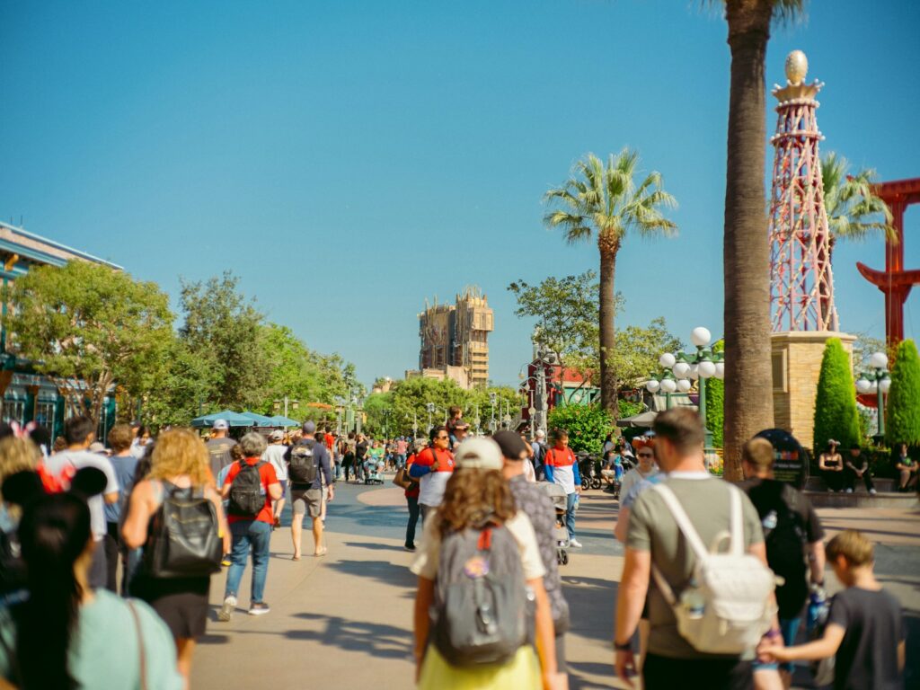 Crowd of people walking in a sunny theme park