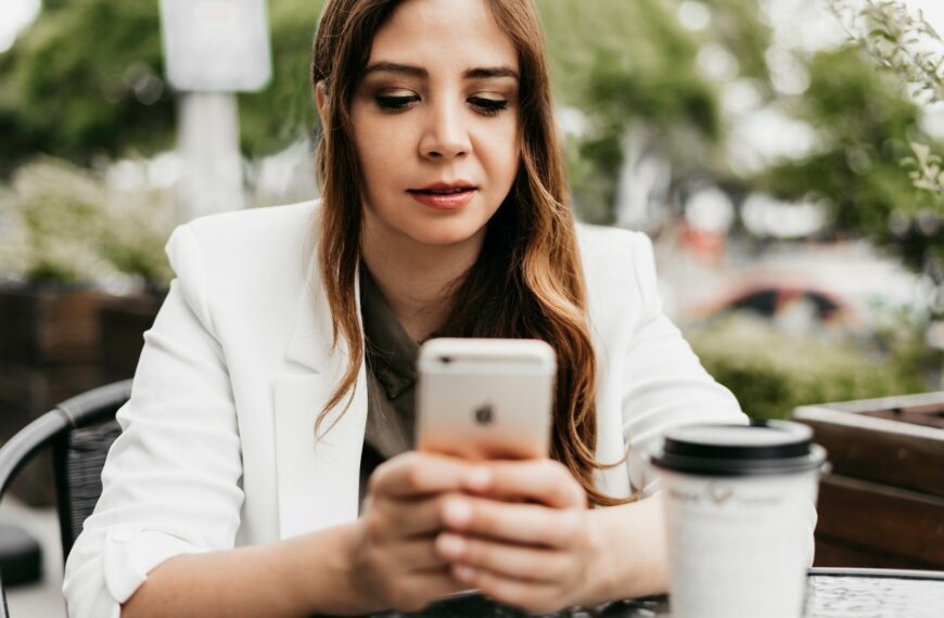 woman in white blazer holding white samsung android smartphone
