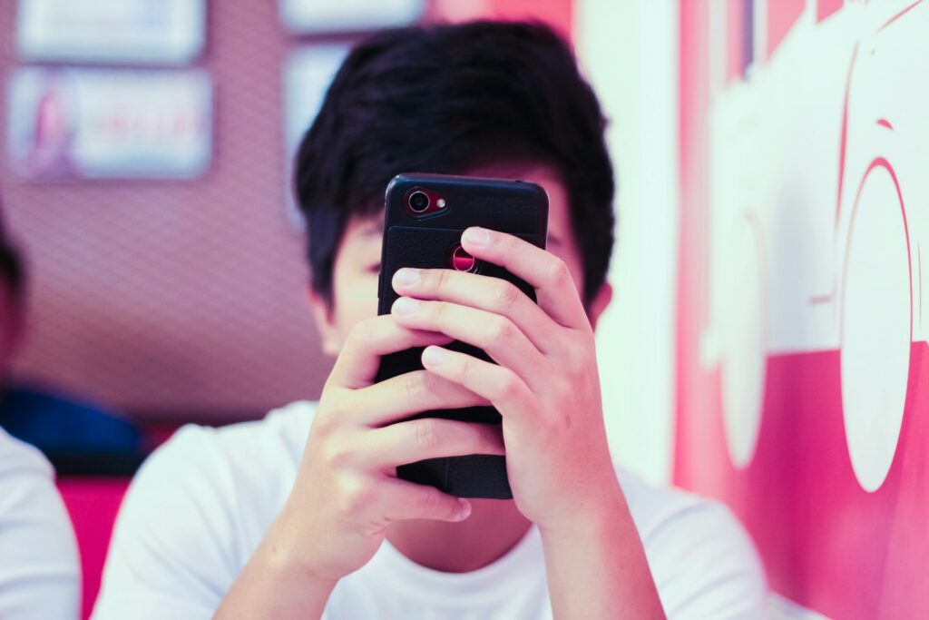man in white crew neck t-shirt holding black iphone 5