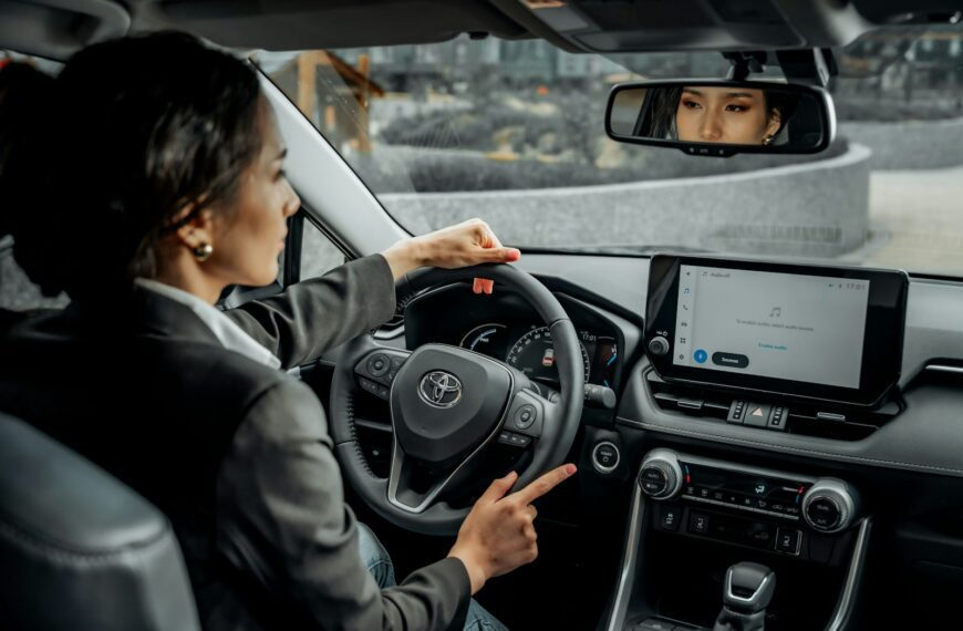 A woman driving a car with a man in the back seat