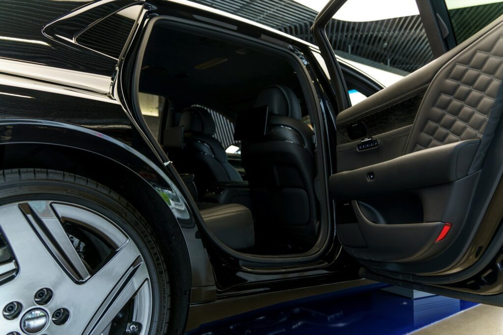 a car with its door open on a showroom floor