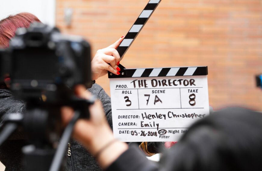 Close-up of film clapperboard in action with camera filming a take on set.