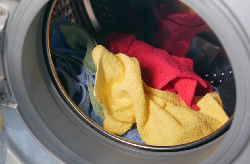 Vibrant close-up of multicolored towels inside a washing machine, ready for a wash.