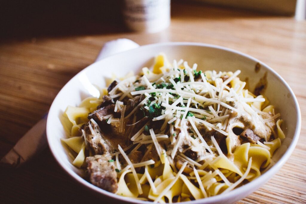 Delicious pasta with creamy mushroom sauce and Parmesan, garnished with herbs.