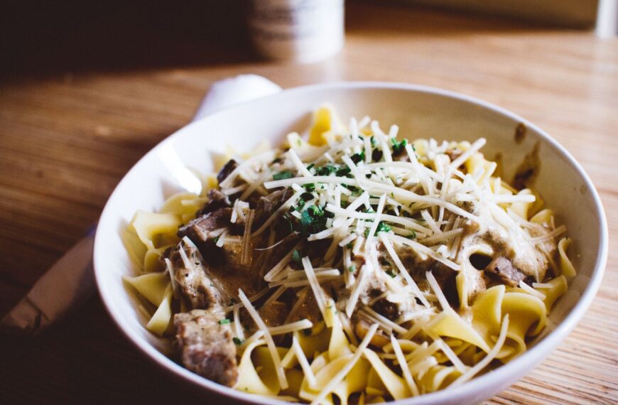 Delicious pasta with creamy mushroom sauce and Parmesan, garnished with herbs.