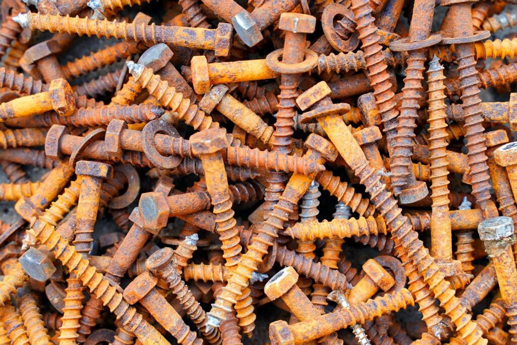 Detailed image showing a heap of rusty screws and bolts, capturing textures and colors.