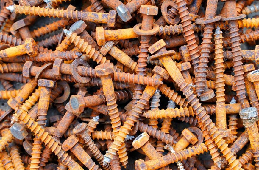 Detailed image showing a heap of rusty screws and bolts, capturing textures and colors.