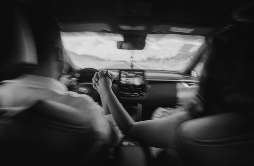 A couple holding hands while driving through the scenic roads of Brazil in a monochrome setting.