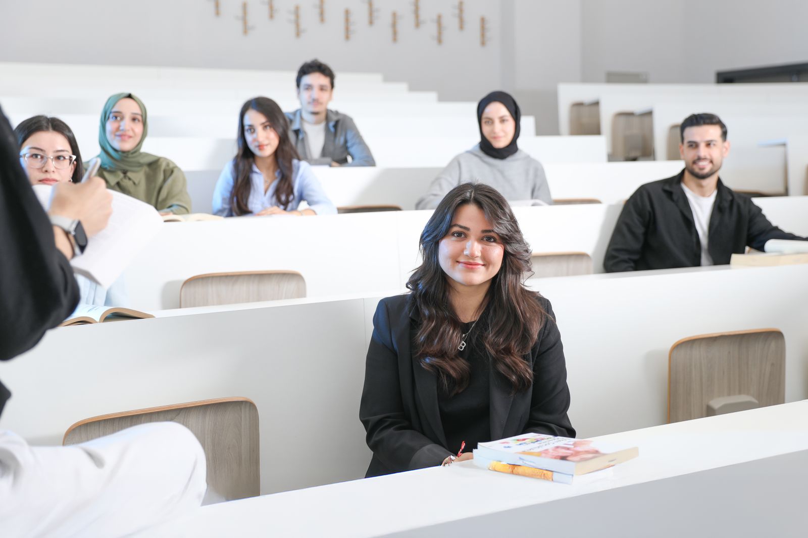 Students listening attentively in a bright university lecture hall.