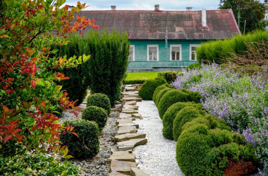 Lush garden with vibrant plants and a rustic house in Pinsk, Belarus.