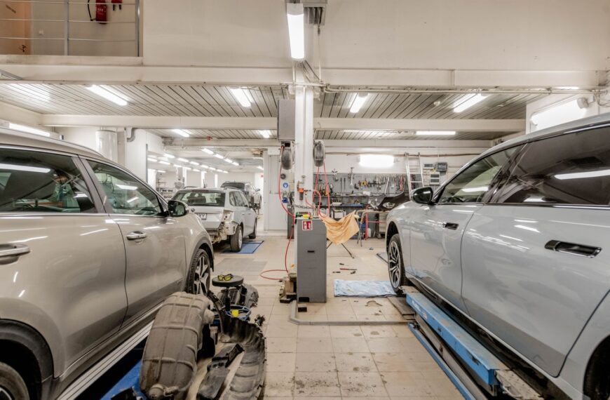 Interior of an automotive repair shop with cars undergoing maintenance and servicing.