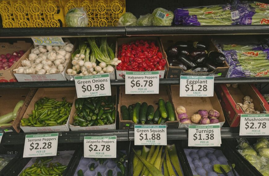 Fresh vegetables including peppers, squash, and mushrooms in a grocery store produce aisle.