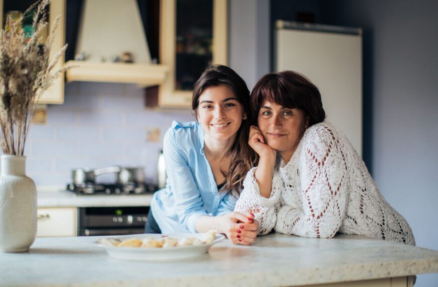 A mother and daughter bonding in the kitchen, smiling and enjoying their time together.