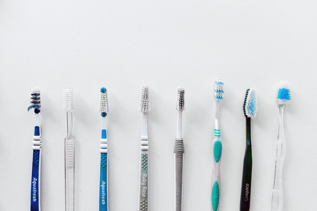 Diverse selection of toothbrushes lined up for dental hygiene focus with copy space.