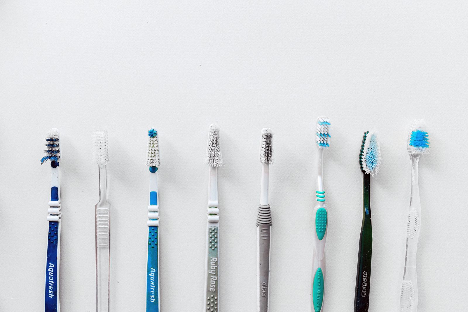 Diverse selection of toothbrushes lined up for dental hygiene focus with copy space.