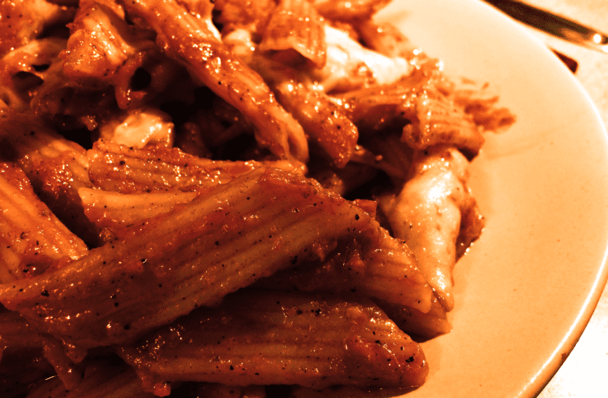 Close-up of mouthwatering penne pasta in red sauce, perfect for Italian cuisine lovers.