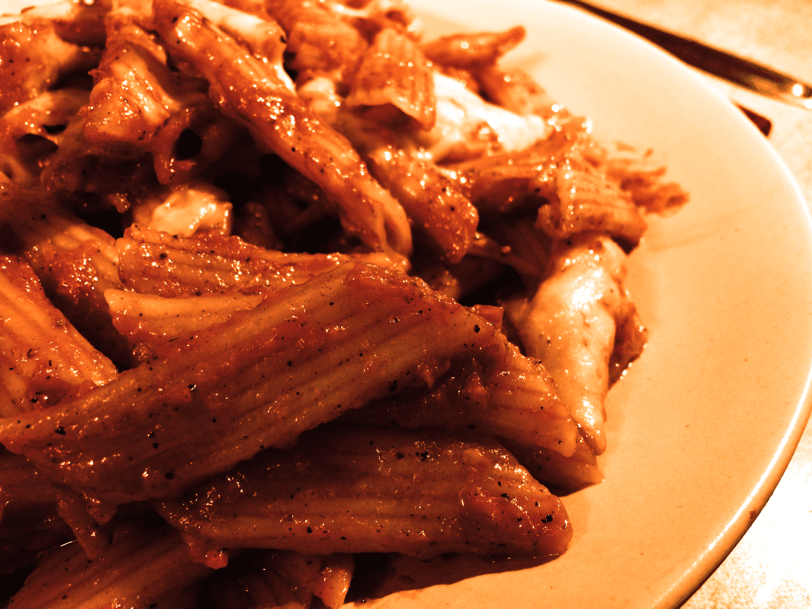 Close-up of mouthwatering penne pasta in red sauce, perfect for Italian cuisine lovers.