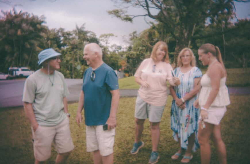 A group of five people standing on grass