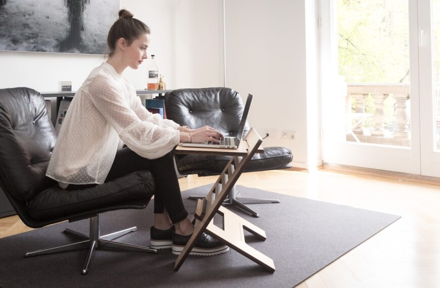 woman in white long sleeve shirt sitting on black leather armchair